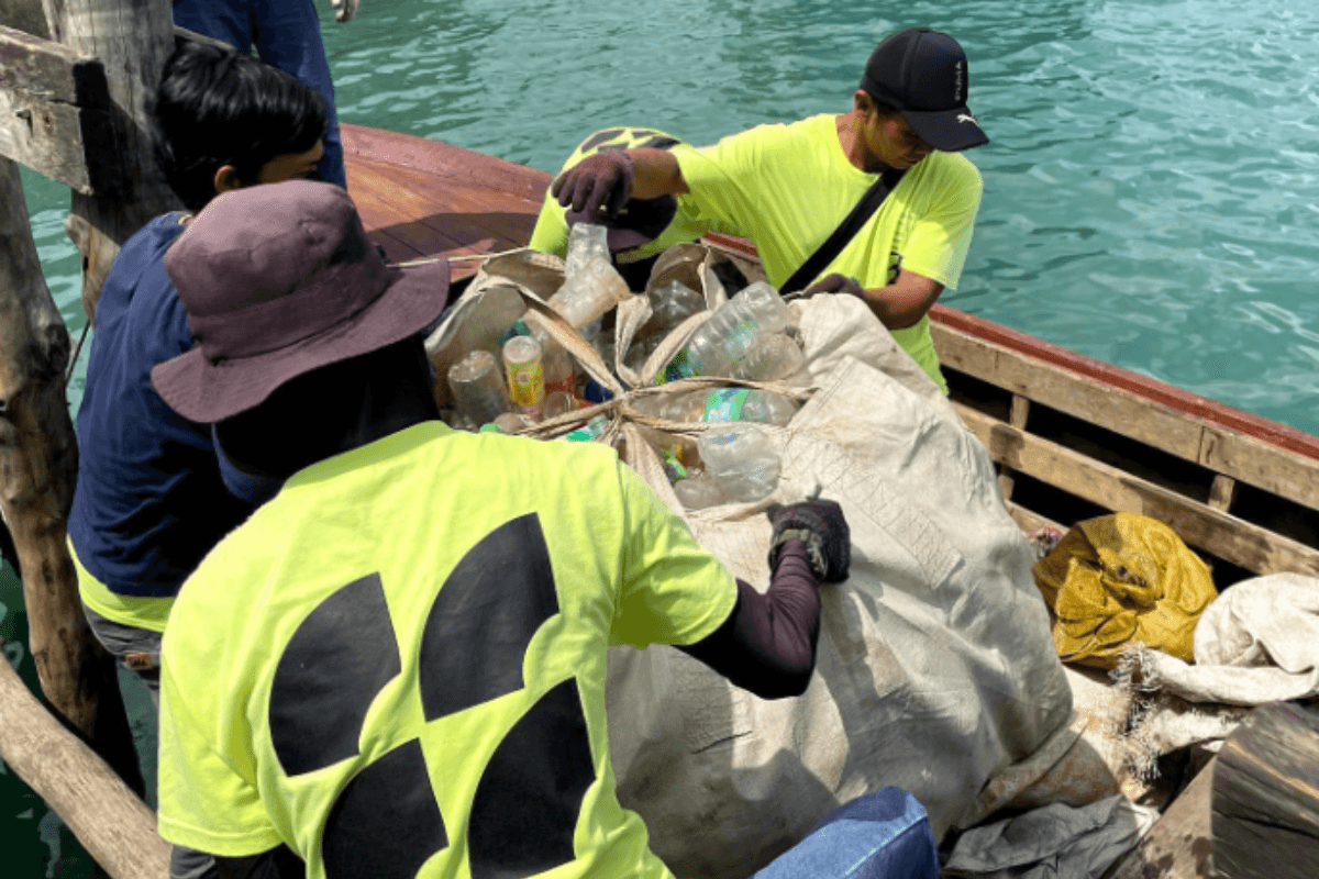 Seven Clean Seas workers cleaning with trash on boat